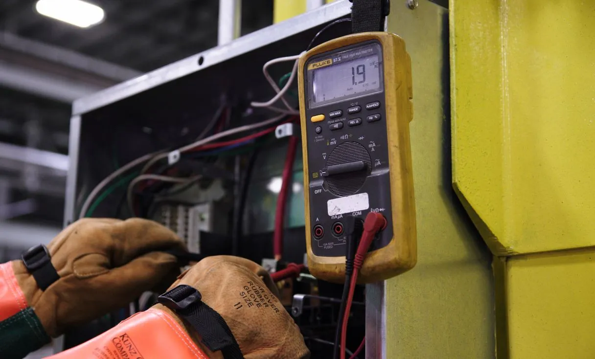 Eletricista medindo no quadro de energia representando: OS no serviço avulso do eletricista: cobrança simples, sem calote