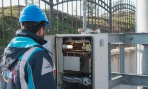 Eletricista inspecionando quadro de luz com multímetro, representando: Eletricista: cobrar visita/diagnóstico quando o serviço não é aprovado (como avisar antes, recibo, OS)