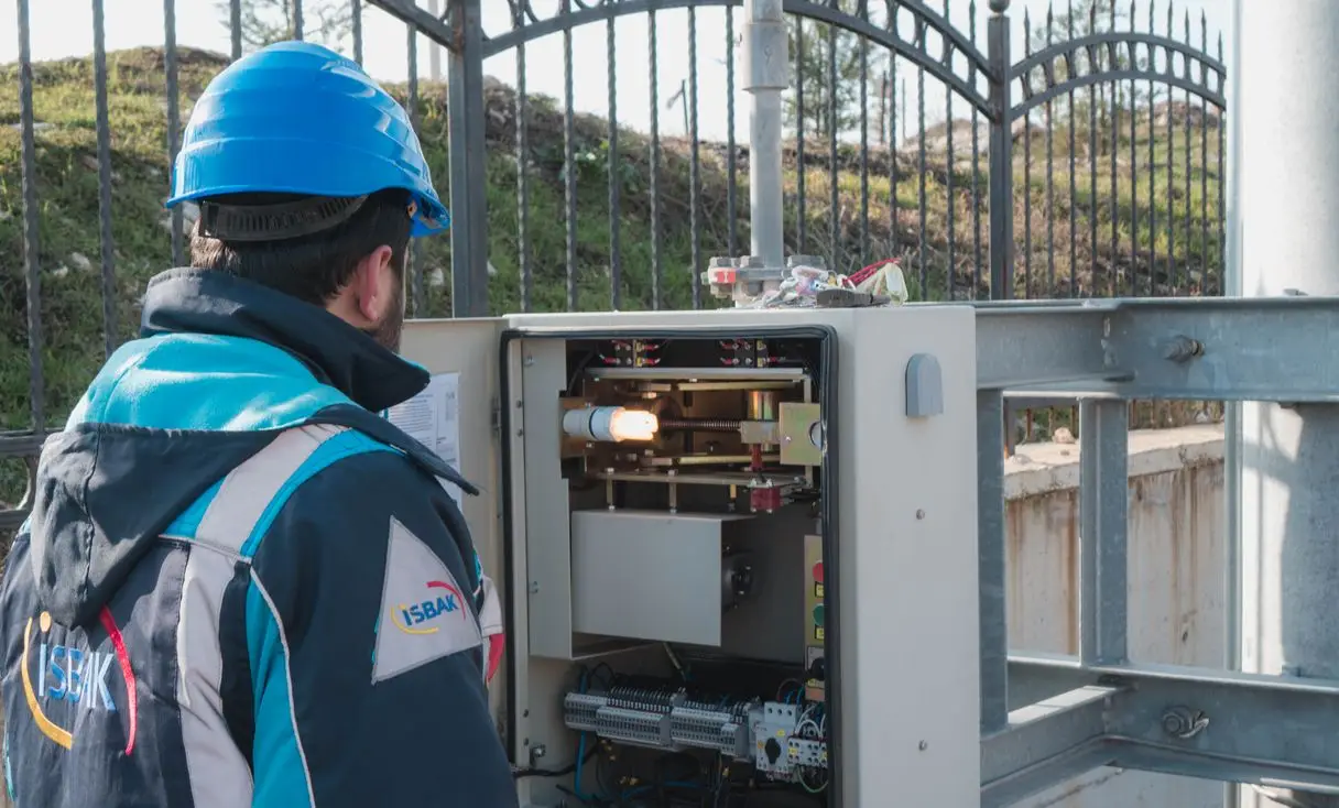 Eletricista inspecionando quadro de luz com multímetro, representando: Eletricista: cobrar visita/diagnóstico quando o serviço não é aprovado (como avisar antes, recibo, OS)