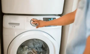 Close de mãos ajustando painel de máquina de lavar representando: Eletrodomésticos — Retirada e devolução de máquina pesada: termo de retirada e quando cobrar segundo retorno
